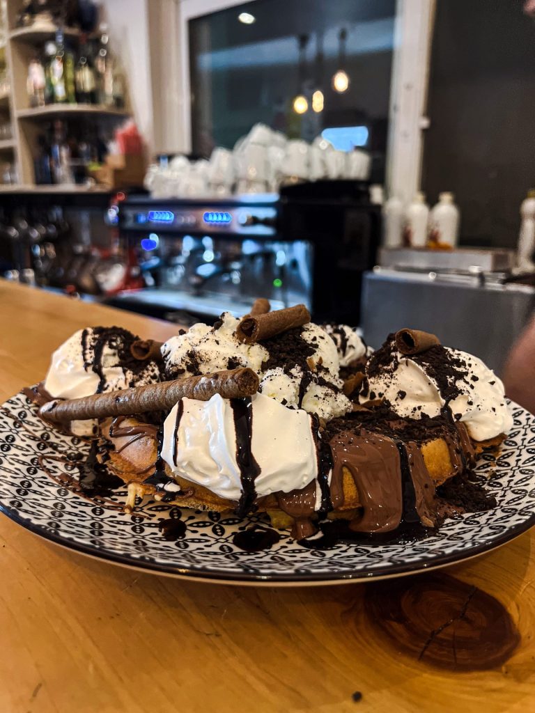 American breakfast with eggs, bacon, sausages and baguette at Fabricia Café, Spili